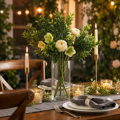 Green boxwood sprays with white flowers in a glass vase on a table - thumbnail number 2