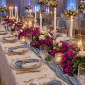 Bougainvillea and white floral centerpieces decorate a candlelit wedding table - thumbnail number 3