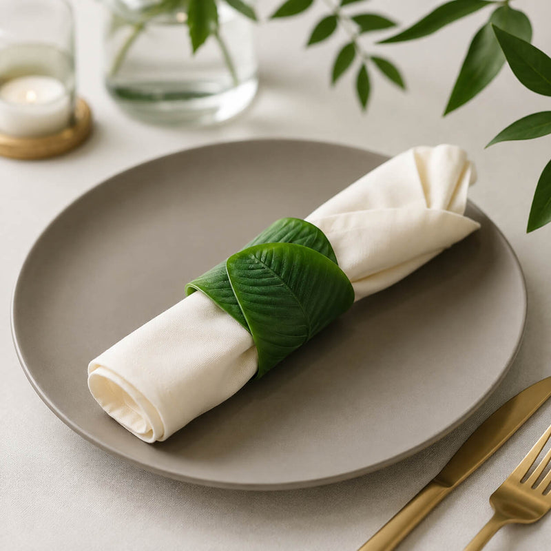 Banana leaf napkin ring holding a folded white napkin on a grey plate - thumbnail number 9