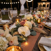 Outdoor wedding reception table decorated with warm white fairy lights and floral centerpieces - thumbnail number 5