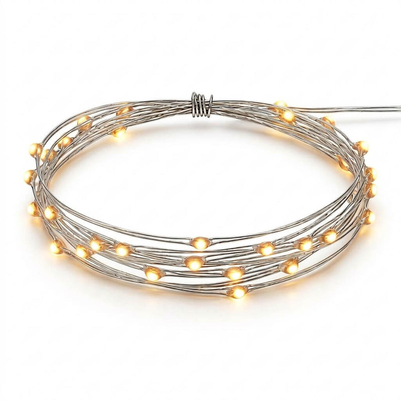 A coiled strand of glowing warm white battery-operated LED fairy lights on a white background - thumbnail number 1