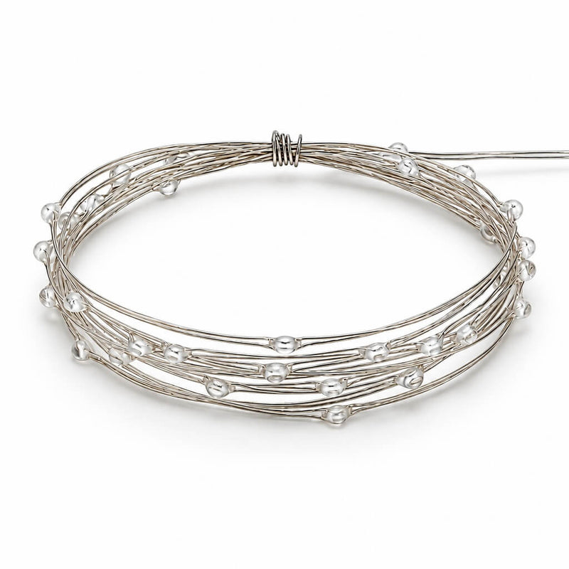A coiled coil of battery-operated warm white LED fairy lights on a white background - thumbnail number 2