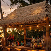 Outdoor tiki bar with artificial thatch roof and string lights at sunset - thumbnail number 5