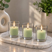 Three lit green votive candles in clear glass holders on an oval marble tray with decor - thumbnail number 10