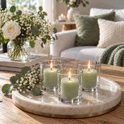 Three lit green votive candles in clear glass holders on a round marble tray styled with baby's breath - thumbnail number 11