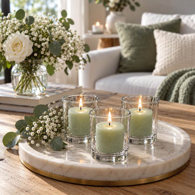 Three lit green votive candles in clear glass holders on a round marble tray styled with baby's breath - thumbnail number 11