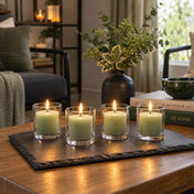 Four lit green votive candles in clear glass holders displayed on a dark slate tray - thumbnail number 12