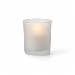 Frosted glass votive holder with candle on white background