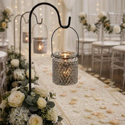 Patterned glass lanterns on hooks lining a wedding walkway with flower petals - thumbnail number 5