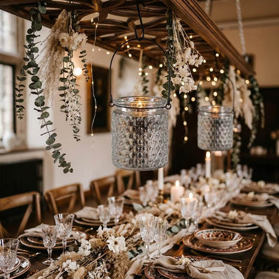 Festive dining decor with lit glass lanterns and floral arrangements. - thumbnail number 6