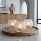 Three glowing frosted glass votive holders on a wooden tray in a bright minimalist interior - thumbnail number 8