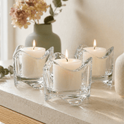 Three lit candles in clear glass holders on a stone surface with a blurred background - thumbnail number 9