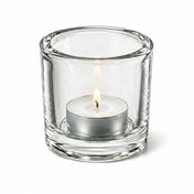 Lit tealight candle in clear glass holder on white background - thumbnail number 3