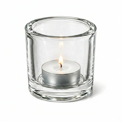 Lit tealight candle in clear glass holder on white background - thumbnail number 3