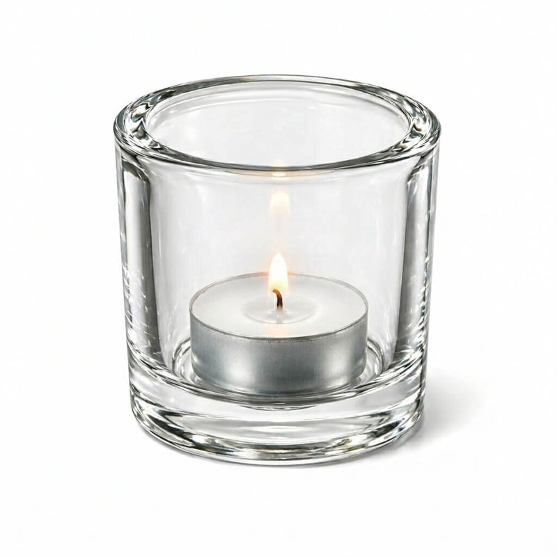 Lit tealight candle in clear glass holder on white background - thumbnail number 3