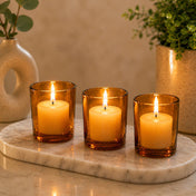 Amber glass votive candles glowing on marble tray in cozy home setting - thumbnail number 7