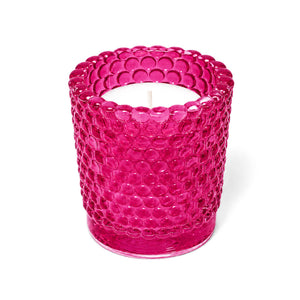 Pink hobnail glass votive holder with white candle on white background