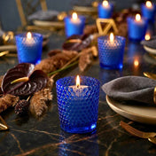 Blue hobnail votive holders with glowing candles on elegant dark table with gold accents - thumbnail number 6