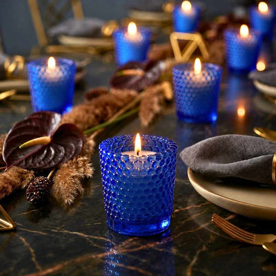 Blue hobnail votive holders with glowing candles on elegant dark table with gold accents - thumbnail number 6