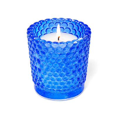 Blue hobnail glass votive candle holder with lit white candle on white background - thumbnail number 3