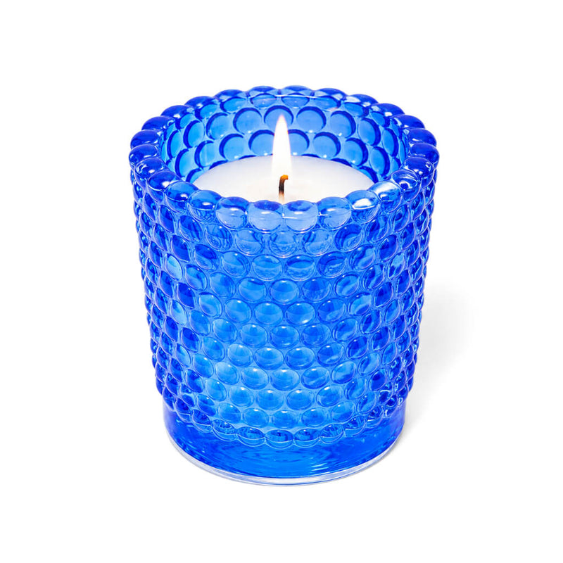 Blue hobnail glass votive candle holder with lit white candle on white background - thumbnail number 3