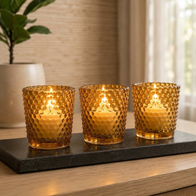 Three amber hobnail votive candles glowing on black tray in cozy home setting - thumbnail number 7