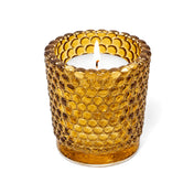 Amber hobnail glass votive candle holder with lit white candle on white background - thumbnail number 3