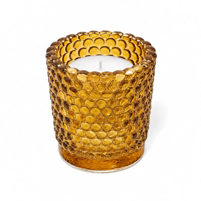 Amber hobnail glass votive candle holder with white candle on white background - thumbnail number 2