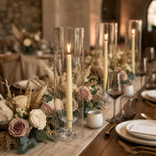 Lit ivory taper candles in glass hurricanes on rustic dining table - thumbnail number 3