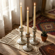 Lit ivory taper candles in silver holders on rustic wooden table - thumbnail number 7