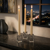 Elegant ivory taper candles in glass holders on dark countertop - thumbnail number 6
