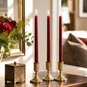 Three lit red taper candles in gold holders on wooden table - thumbnail number 6
