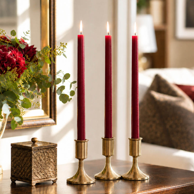 Three lit red taper candles in gold holders on wooden table - thumbnail number 6