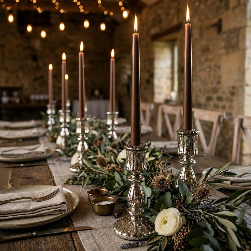 Lit brown taper candles on a long rustic dining table with floral decor - thumbnail number 4