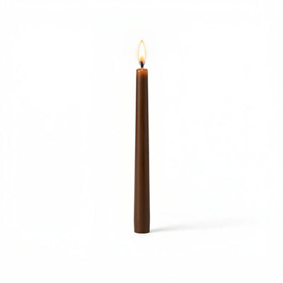 Single brown taper candle with flame on white background - thumbnail number 2