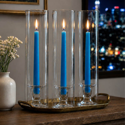 Blue taper candles in glass hurricane holders on wooden tabletop - thumbnail number 6