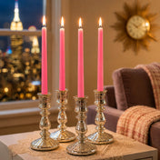 Four lit pink taper candles in silver holders on cozy tabletop - thumbnail number 7