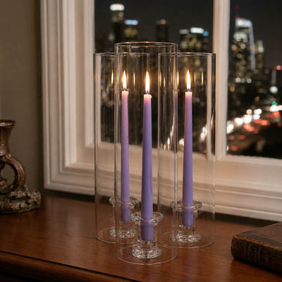 Lavender candles in clear glass holders on table near nighttime window - thumbnail number 7