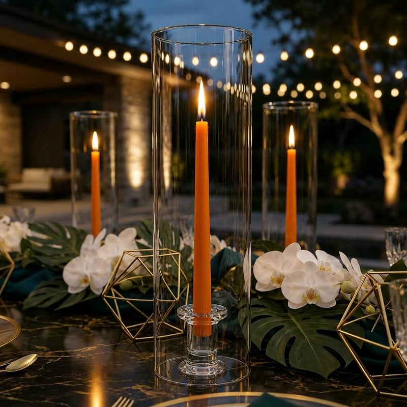 Outdoor evening tablescape with orange taper candles in glass cylinder vases - thumbnail number 3