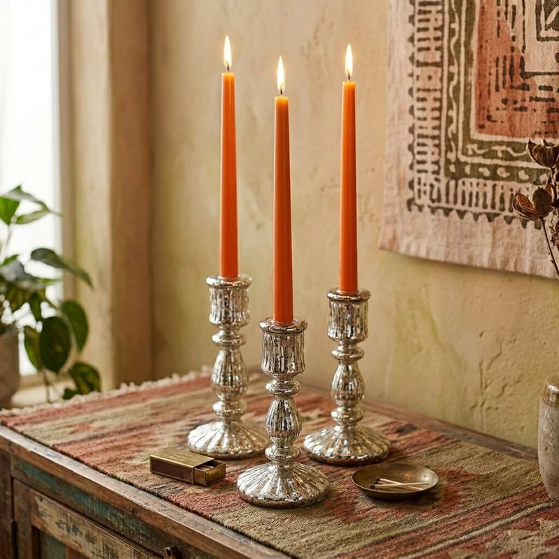 Three orange taper candles in silver holders on rustic wooden table - thumbnail number 6
