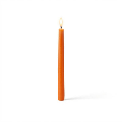 Single orange taper candle with flame on white backdrop - thumbnail number 2
