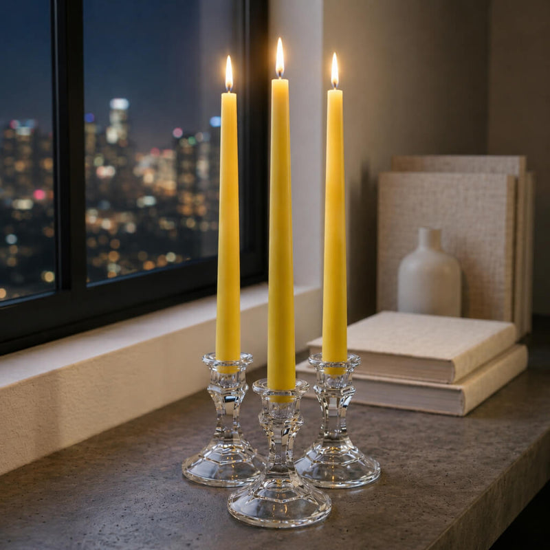 Elegant yellow taper candles on table near window at night - thumbnail number 7