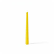 Single yellow taper candle on white backdrop - thumbnail number 1