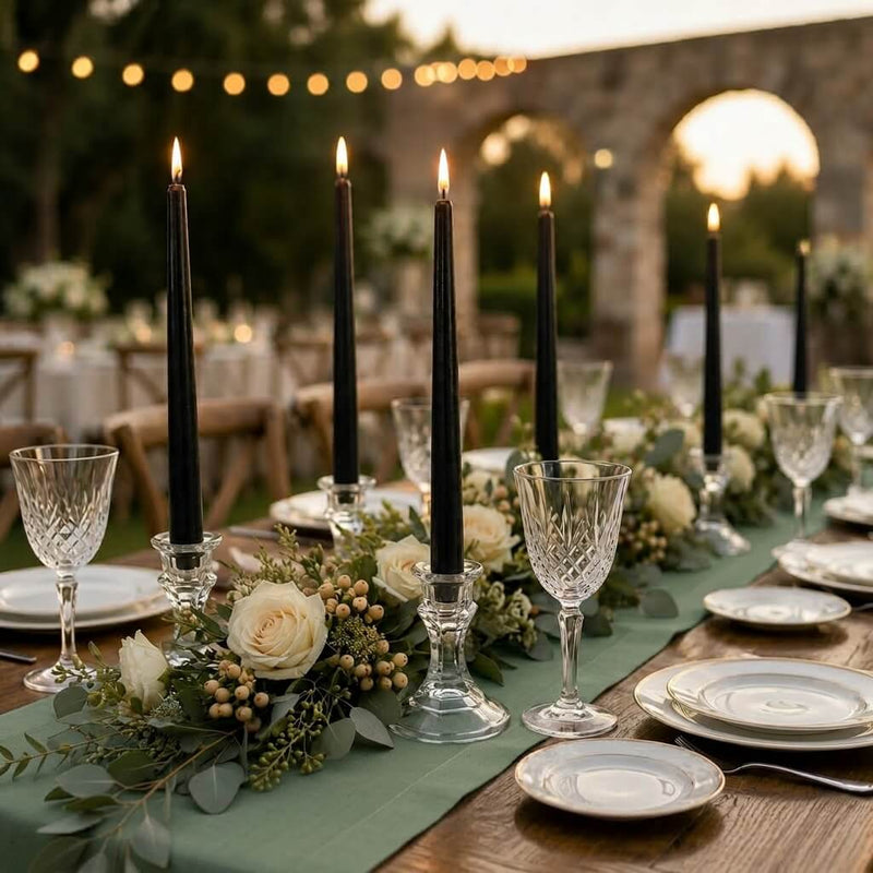 Lit black taper candles on outdoor dining table with floral garland - thumbnail number 5