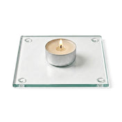 A clean product studio shot of a lit candle sitting on a clear glass Square Coaster 4" - thumbnail number 3