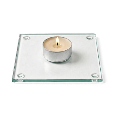 A clean product studio shot of a lit candle sitting on a clear glass Square Coaster 4" - thumbnail number 3