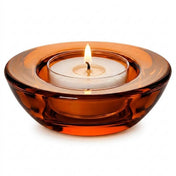 Lit white tealight candle inside a round amber glass holder isolated on a white background - thumbnail number 3