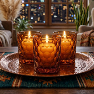 Decorative tray setting with amber candles on a metal tray and in a cozy home.