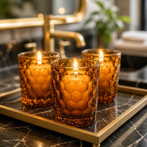 Decorative tray setting with amber candles on a metal tray and in a upscale restroom.