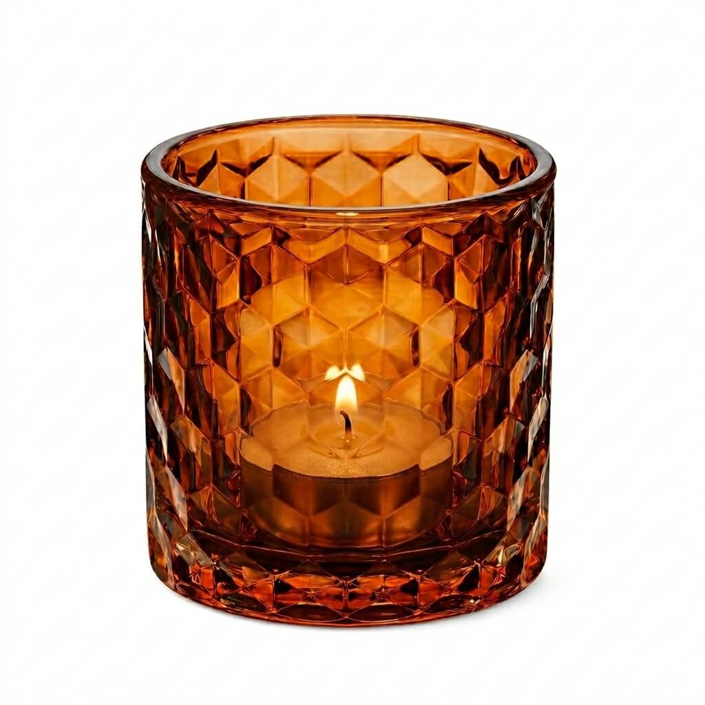 Amber honeycomb glass votive and tealight holder with lit tealight candle on white background
